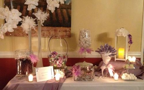 Purple and white table setting with vases with flowers and such