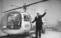 Councilman Howell waves as he stands at the door of a helicopter. 