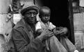 A man with his son, outside their shanty where they squat on government land in Nairobi, Kenya, 1990