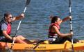 Staff Member Josselyne and Scholar Andres sailing through a lake on a canoe.