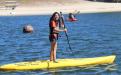 Scholar Melisa Morales paddle boarding on the lake.