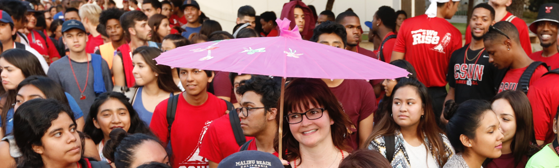 U100 faculty member Corri Ditch (under parasol) with students headed for Freshman Convocation 2015.
