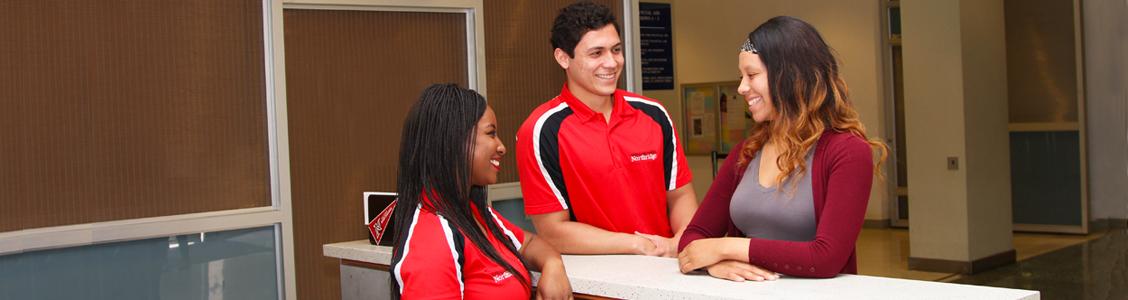 Employees helping someone at the Guest Relations front desk.