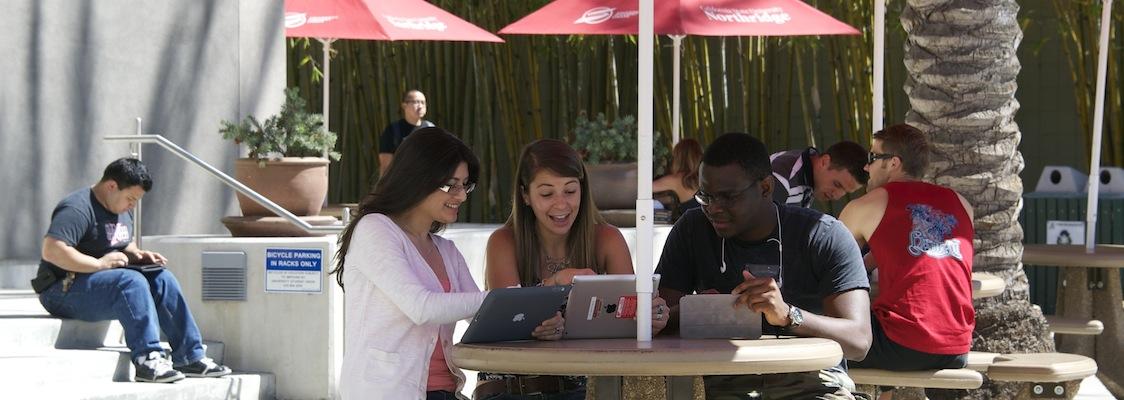 Students use iPads outside to study and collaborate.