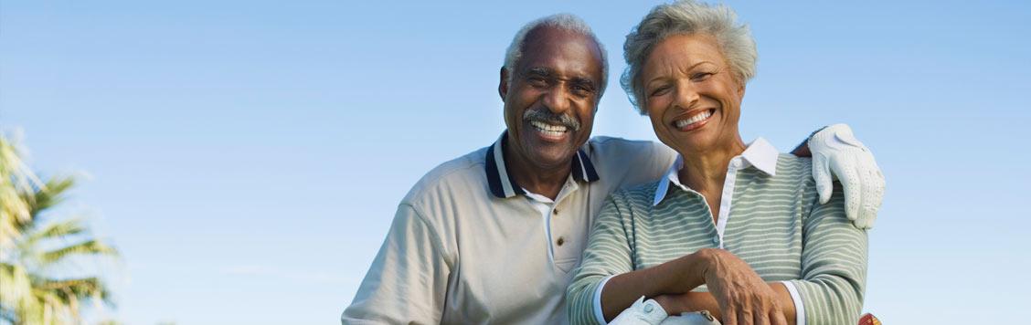 Smiling African American middle aged couple smiling at the camera.