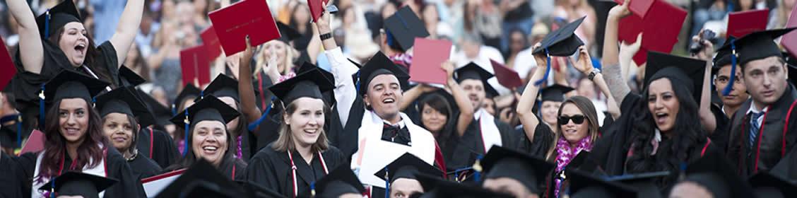 Graduates holding up diplomas in triumph