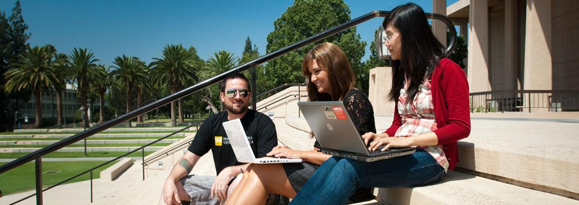 Students using a laptop in front of the Oviatt Library