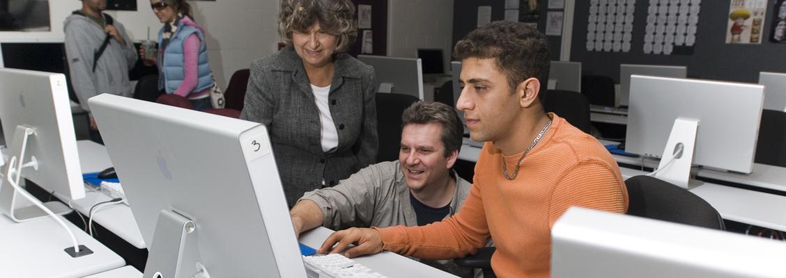 Two faculty and a student using a desktop