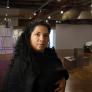 Beatriz Cortez standing in a large room in front of metallic art sculptures