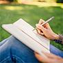 Woman writing in journal outside