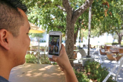 A student using Zoom on his smartphone. 